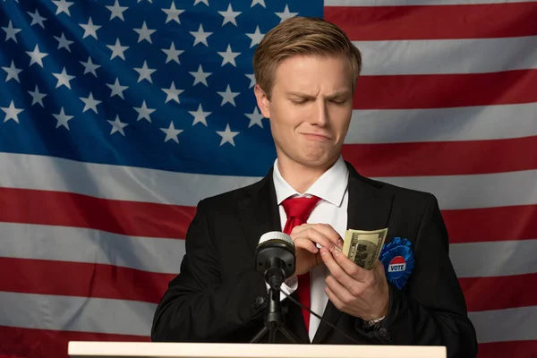 Mann Mit Bargeld Auf Tribüne Vor Hintergrund Amerikanischer Flagge — Stockfoto