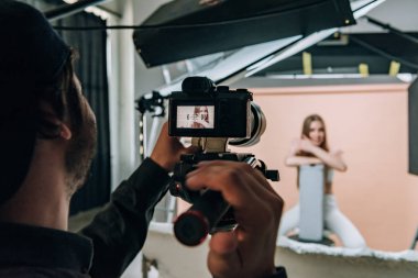 Fotoğraf stüdyosunda güzel bir model çeken kameramanların omuz üstü görüntüsü