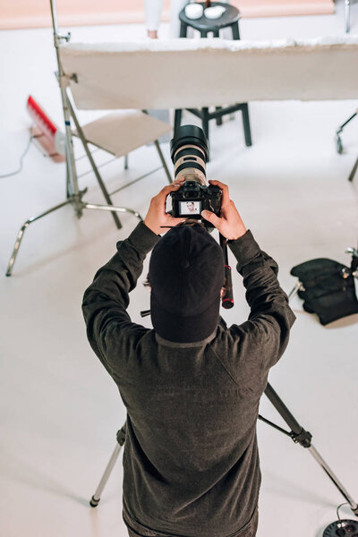 Overhead view of cameraman looking at camera display in photo studio