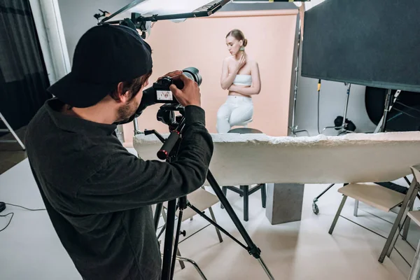 Cameraman Olhando Para Exibição Câmera Enquanto Filma Modelo Atraente Estúdio — Fotografia de Stock