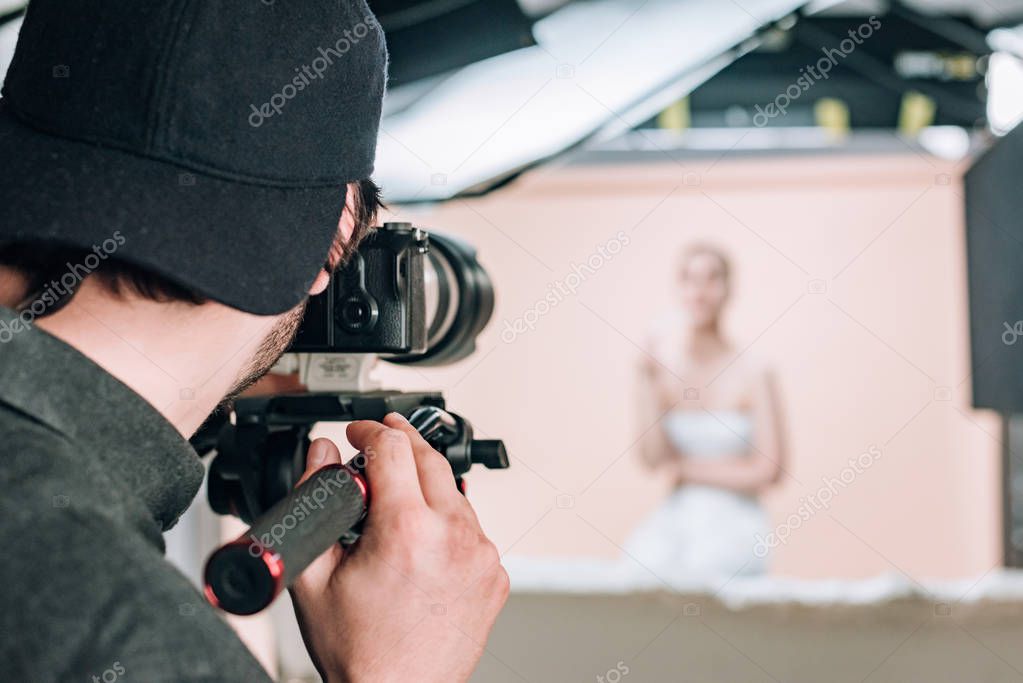 Back view of operator and model working in photo studio