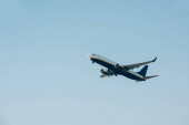 Nízký úhel pohledu na odlet letadla na modré obloze