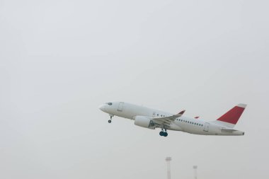 Ticari jet uçağı arka planda bulutlu gökyüzü ile kalkıyor.