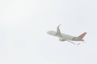 Bulutlu havada havalanan ticari uçağın alçak açılı görüntüsü