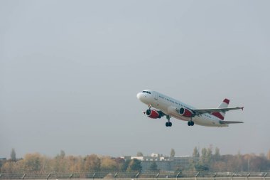 Commercial plane departure on airport airfield with cloudy sky at background clipart