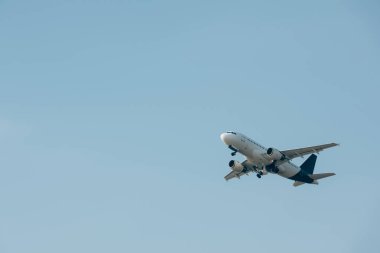 Mavi gökyüzünde havalanan uçağın alçak açılı görüntüsü
