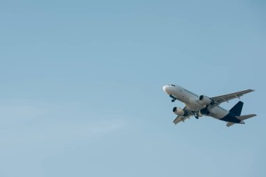 Commercial jet plane landing in blue sky  clipart
