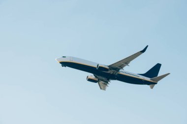 Ticari jet uçağı mavi gökyüzünde havalanıyor.