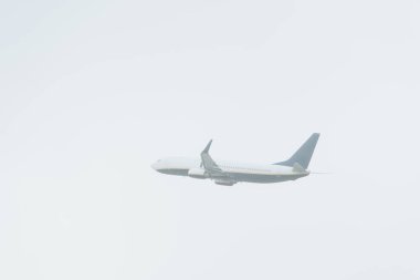 Arka planda bulutlu gökyüzü olan jet uçağının alçak açılı görüntüsü