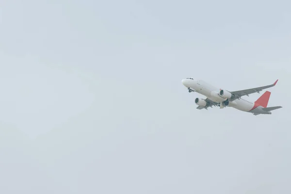 Bulutlu Gökyüzüne Inen Uçağın Alçak Açılı Görüntüsü — Stok fotoğraf