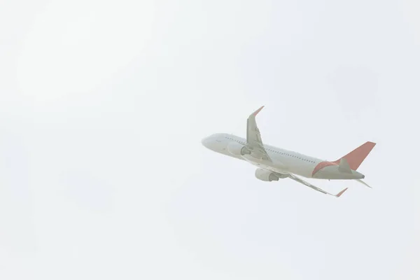 Bulutlu Havada Havalanan Ticari Uçağın Alçak Açılı Görüntüsü — Stok fotoğraf