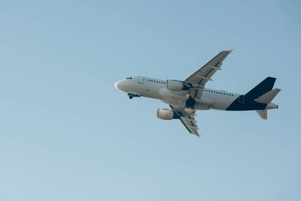 Low angle view of commercial plane taking off in blue sky