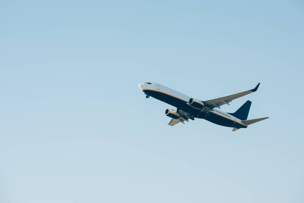 Low angle view of jet liner taking off in blue sky