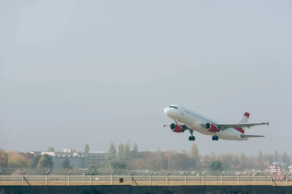 背景に曇り空の滑走路から離陸する飛行機 ロイヤリティフリーのストック画像