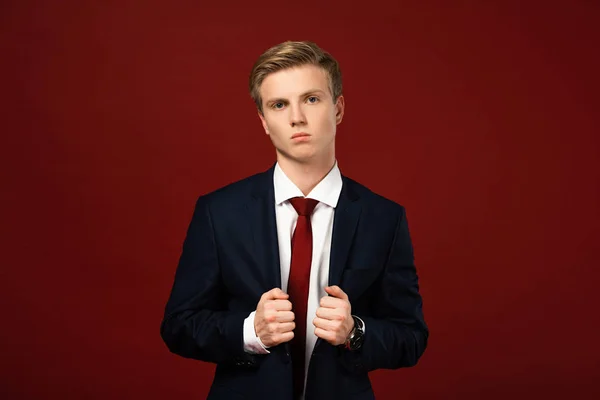 Uomo sicuro in giacca e cravatta su sfondo rosso — Foto stock