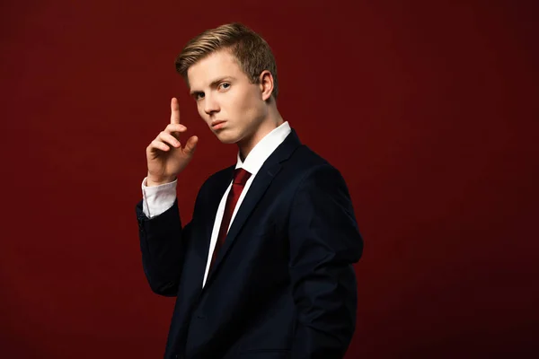 Confident man showing idea gesture on red background — Stock Photo