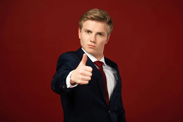 Homem confiante mostrando polegar no fundo vermelho — Fotografia de Stock