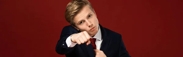 Confident man showing fist on red background — Stock Photo