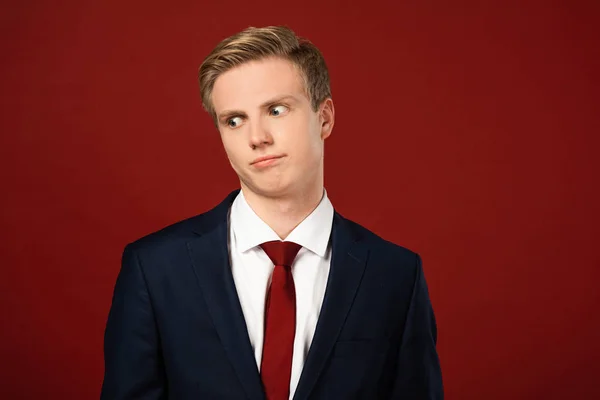 Confused man looking away on red background — Stock Photo