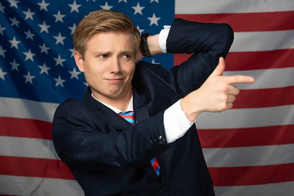 Чоловік вказує пальцем подалі на американському фоні прапора — стокове фото