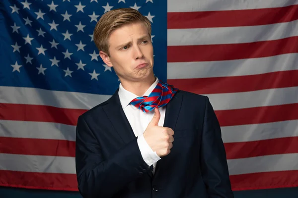 Uomo mostrando pollice su su americano bandiera sfondo — Foto stock