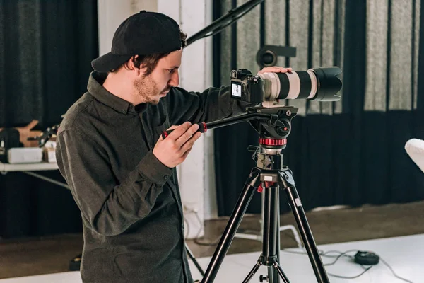 Seitenansicht des Kameramanns bei der Arbeit im Fotostudio — Stockfoto