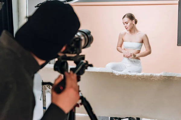 Enfoque selectivo de la hermosa mujer posando al videógrafo en el estudio de fotos - foto de stock