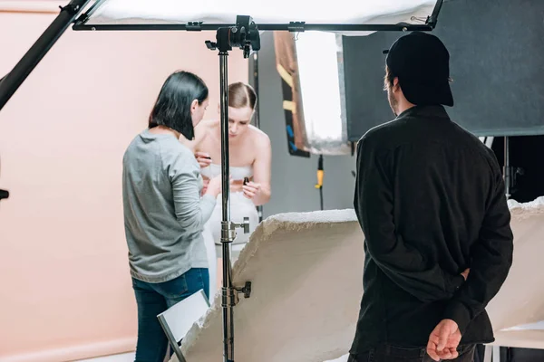 Concentration sélective du vidéaste, du mannequin et de l'assistant dans le studio photo — Photo de stock