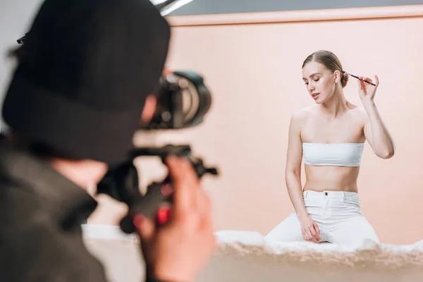 Selektiver Fokus der schönen Frau, die im Fotostudio für den Videofilmer posiert — Stockfoto