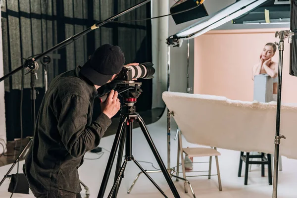 Cameraman filming beautiful woman in photo studio — Stock Photo