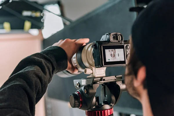 Selective focus of videographer filming woman in photo studio — Stock Photo