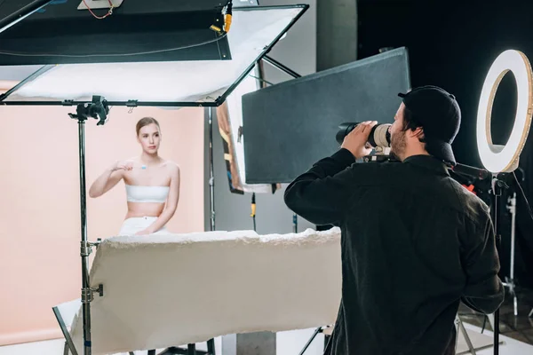 Beautiful female model posing to videographer in photo studio — Stock Photo