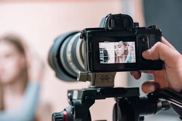 Selective focus of beautiful model on camera display in photo studio — Stock Photo