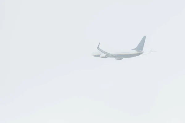 Flight departure of airplane in cloudy sky — Stock Photo