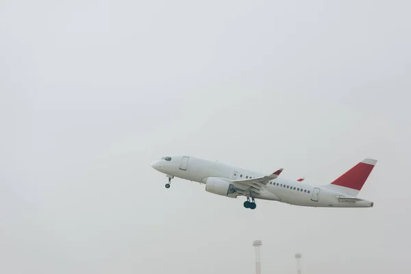 Avión jet comercial despegando con cielo nublado al fondo - foto de stock