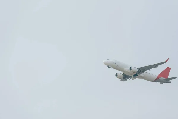Flight departure of jet plane in cloudy sky — Stock Photo