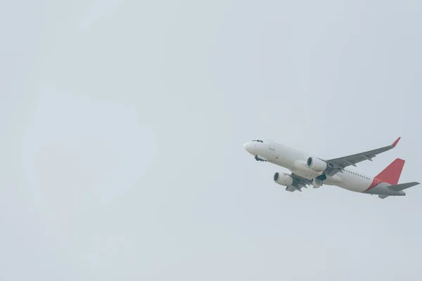 Partenza di volo di aereo a reazione in cielo nuvoloso — Foto stock