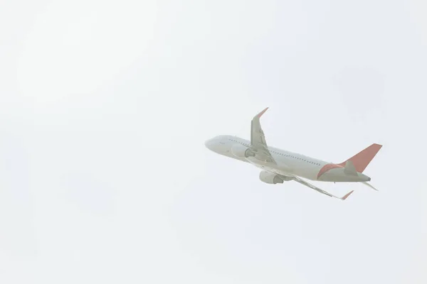 Low angle view of commercial plane taking off in cloudy sky — Stock Photo