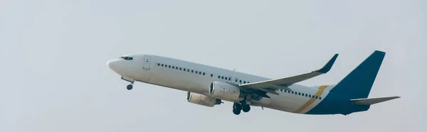 Vista panorámica del avión a reacción despegando en el cielo nublado - foto de stock