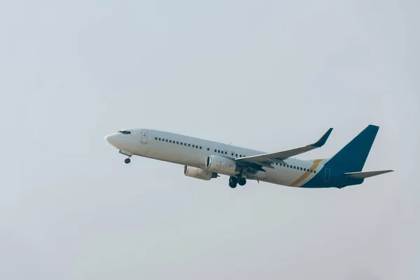 Tieffliegerblick auf startendes Düsenflugzeug bei bewölktem Himmel — Stockfoto