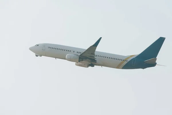 Vue en angle bas du départ en vol de l'avion à réaction dans un ciel nuageux — Photo de stock