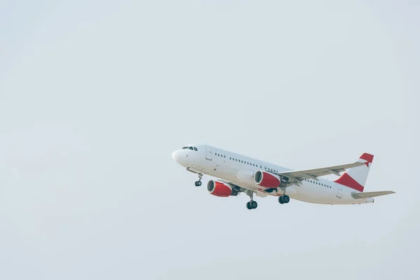 Avião comercial a descolar com céu nublado ao fundo — Fotografia de Stock