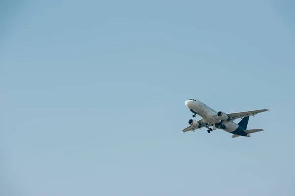 Комерційний реактивний літак злітає в блакитному небі з копіювальним простором. — стокове фото