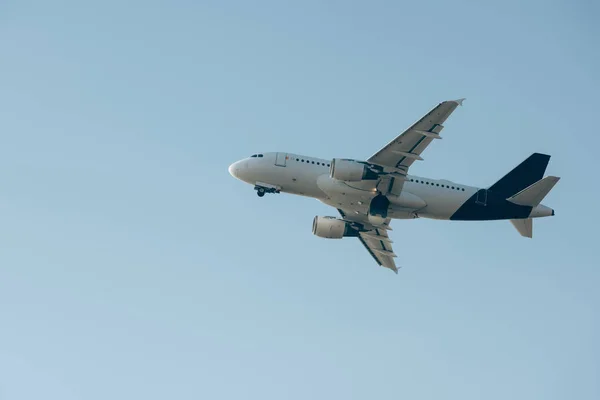 Vista ad angolo basso dell'aereo commerciale che decolla nel cielo blu — Foto stock