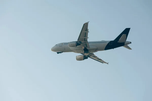 Vista en ángulo bajo de la salida de vuelo del avión en el cielo azul - foto de stock