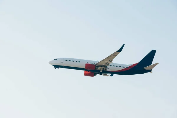 Vue à faible angle de l'avion commercial décollant dans un ciel dégagé — Photo de stock