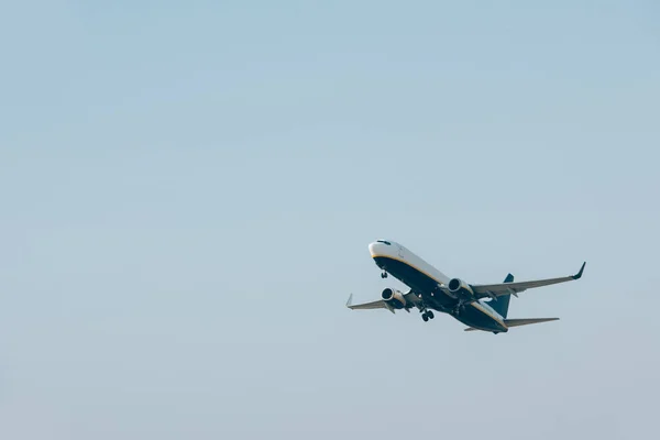 Vue en angle bas de l'avion décollant dans le ciel bleu — Photo de stock