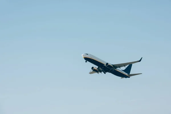 Vista ad angolo basso della partenza dell'aereo in cielo blu con spazio copia — Foto stock