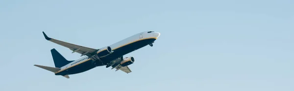 Avion commercial décollant dans le ciel bleu, prise de vue panoramique — Photo de stock