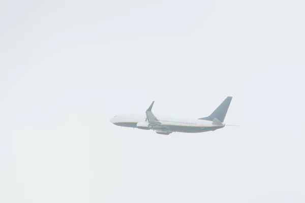 Vista de ángulo bajo del avión jet con cielo nublado en el fondo - foto de stock